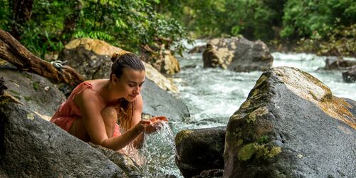 woman drinking creek