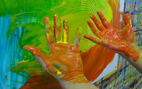 Ausdrucksmalen im Atelier Klang und Farbe - hier darfst du auch mit den Händen malen. Hände vor Papier rot gelb